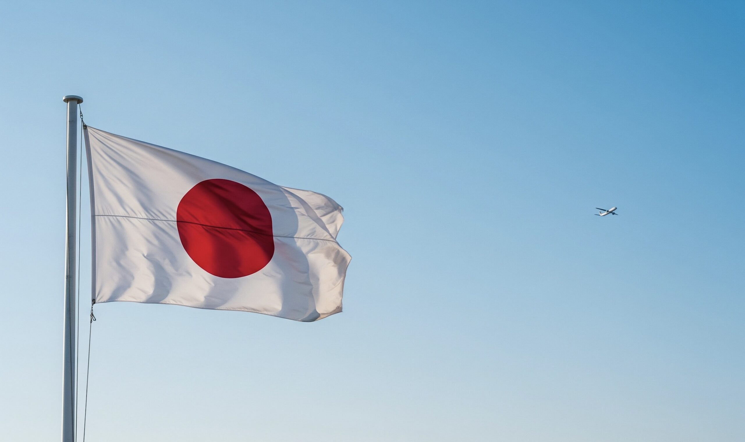 日本の国旗の写真、遠くに飛行機も映り込んでいる